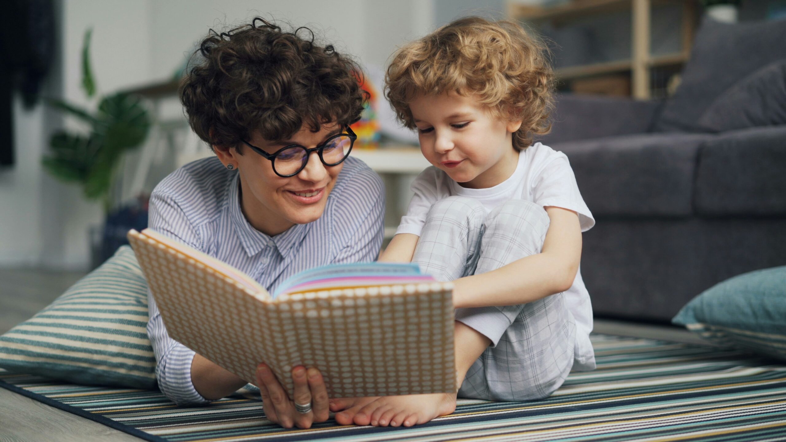 Parent lisant un livre en anglais avec son enfant pour l’aider à apprendre l’anglais dès le plus jeune âge